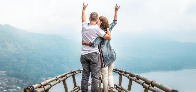 Image of a couple on a bridge overlooking water